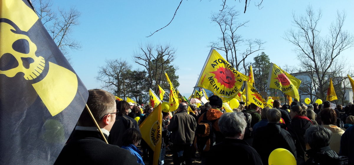 Protest against the plant Fessenheim, with yellow "Atomkraft? neine Danke" banners and a small crowd
