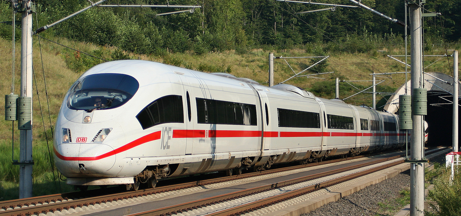 a German high speed train (ICE) coming out of a tunnel and into the woods