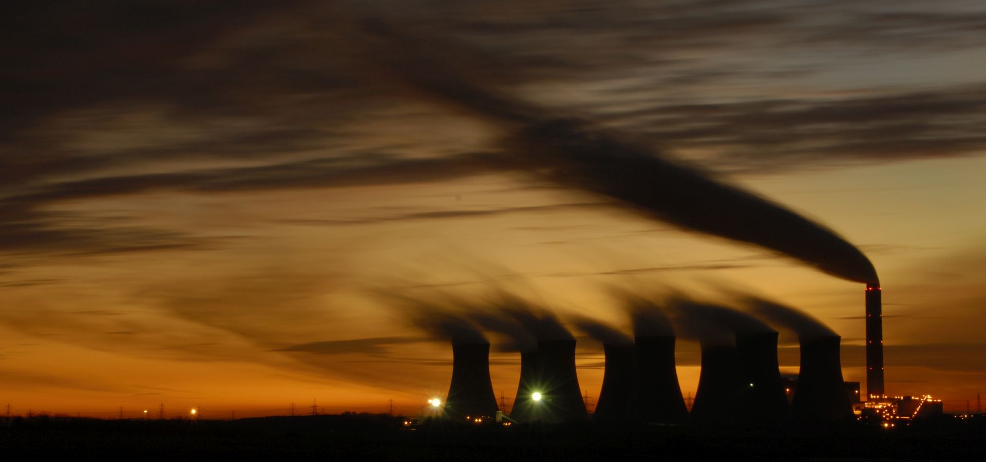 The towers of Cottam Power Station silhoutted against the sky at sunset