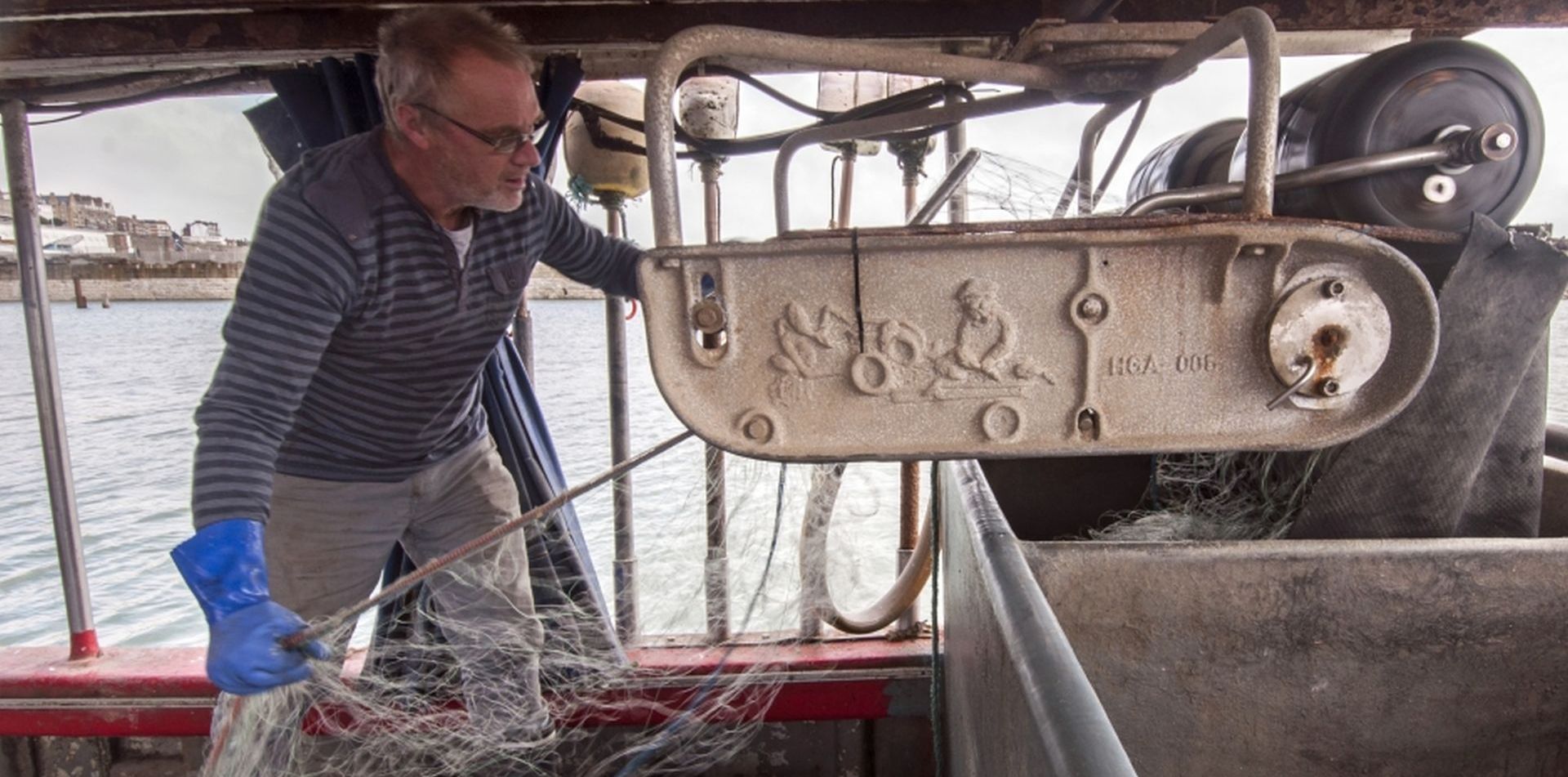 Fisherman Barratt holds an empty net inside of his boat