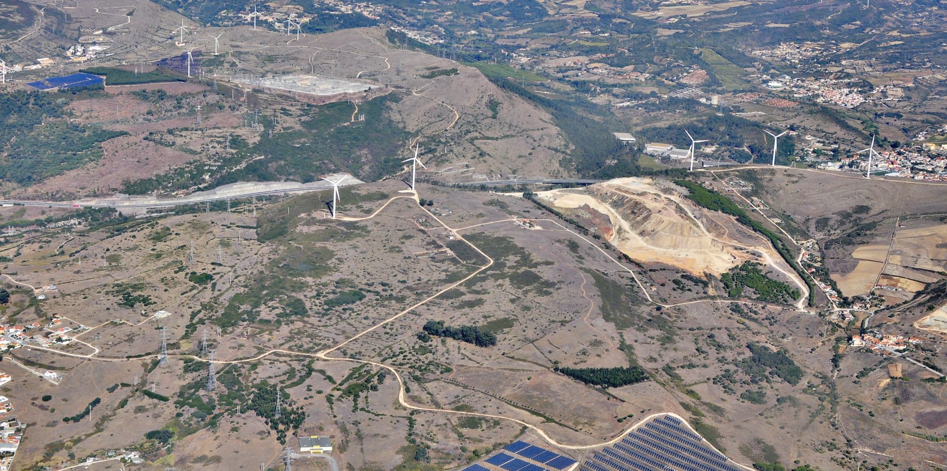 View from the air of Portugese countryside with solar panels and wind turbines