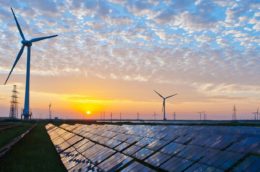 wind turbines and solar panels seen at sunset
