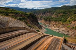 view of dam spillway with red earth and blue water