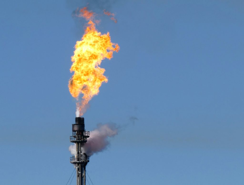 Gas flare on top of a flare stack at an oil refinery.
